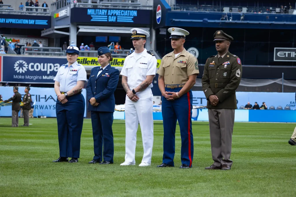 U.S. servicemembers supporting Fleet Week New York stand during a Military Appreciation Day event at Yankee Stadium