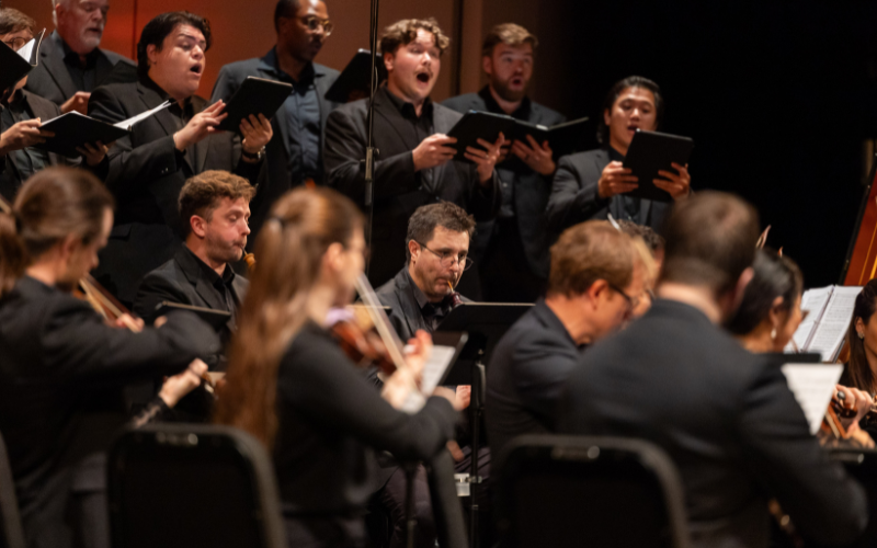Choir and Orchestra on stage with close up on oboe player