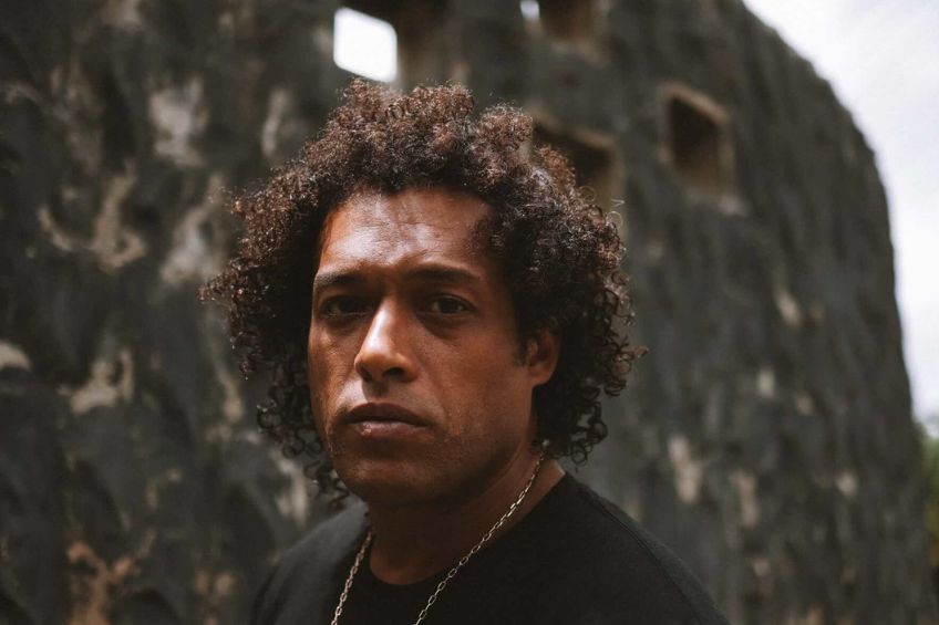 A Black man in his 40s in a black tshirt in an outdoor setting