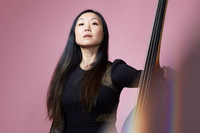 Asian woman with long dark hair and upright bass