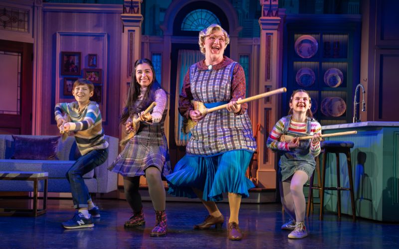 The cast of Mrs. Doubtfire performs a playful family dance number on stage.